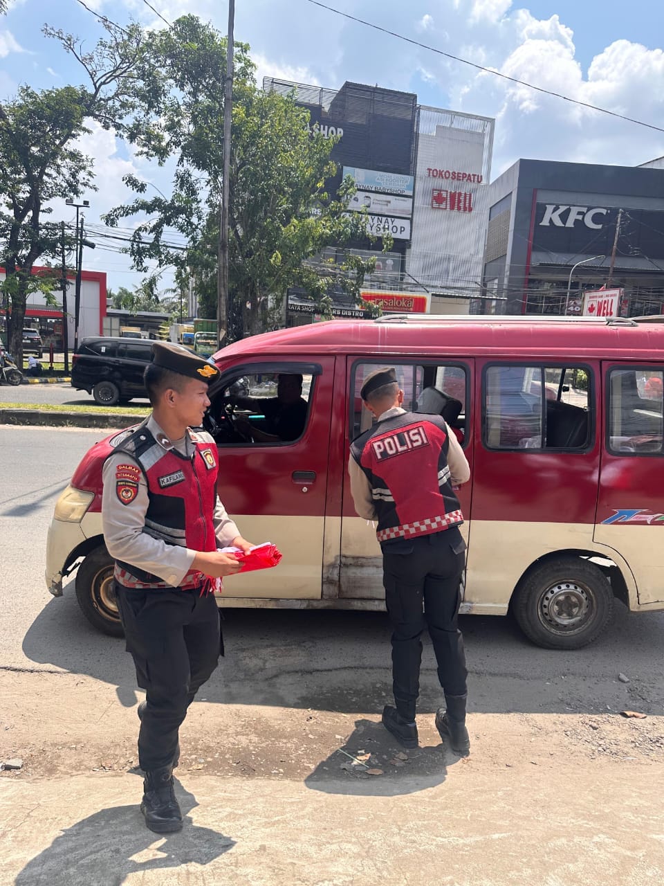 Polda Sumsel Bagikan Bendera Merah Putih Kepada Masyarakat Palembang Menyambut Hut Kemerdekaan RI Ke-80