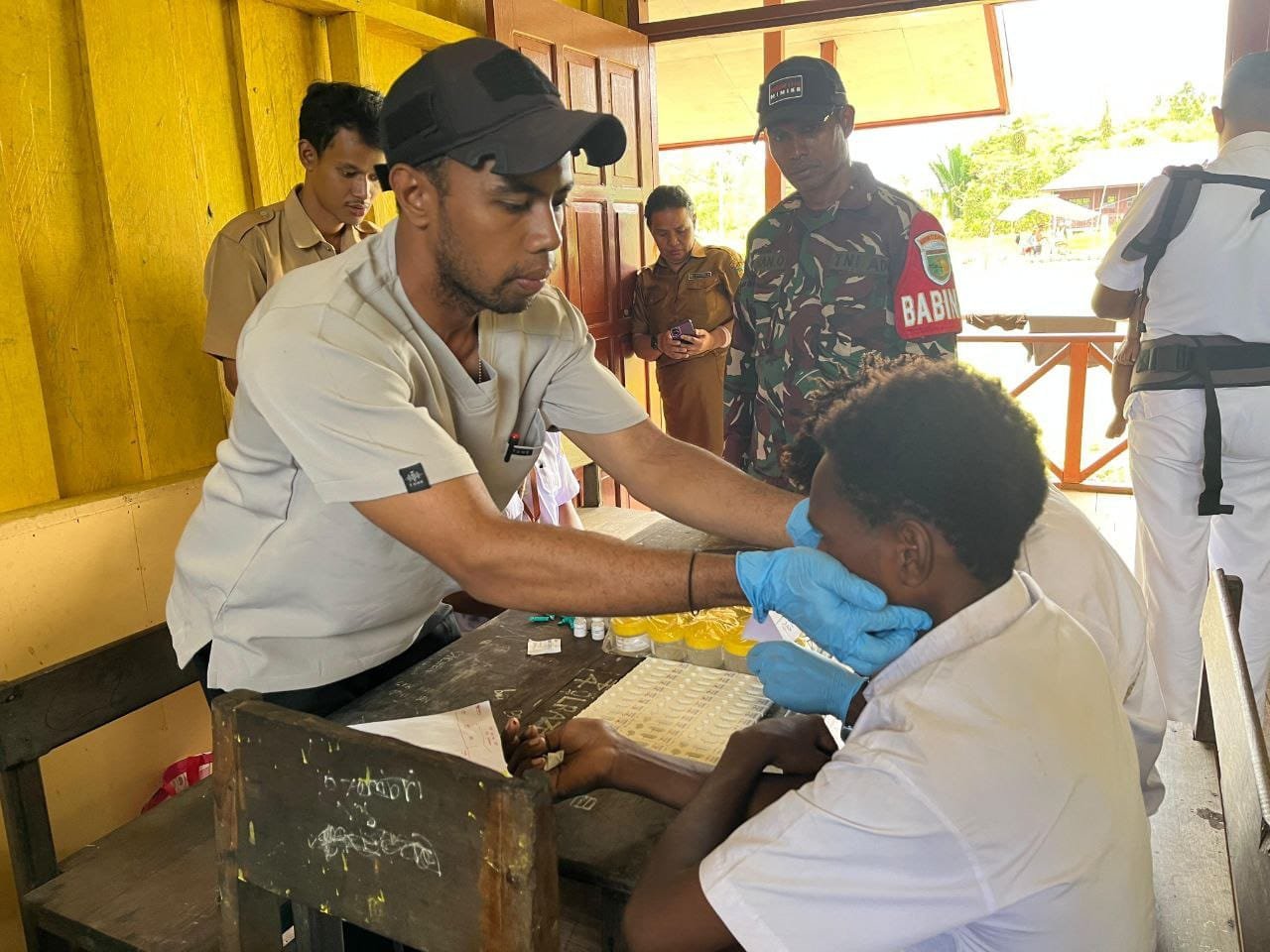Peduli Kondisi Kesehatan Generasi Penerus Bangsa, Babinsa Koramil 1710-06/Agimuga Dampingi Nakes Pada Kegiatan Pemeriksaan Kesehatan Kepada Pelajar
