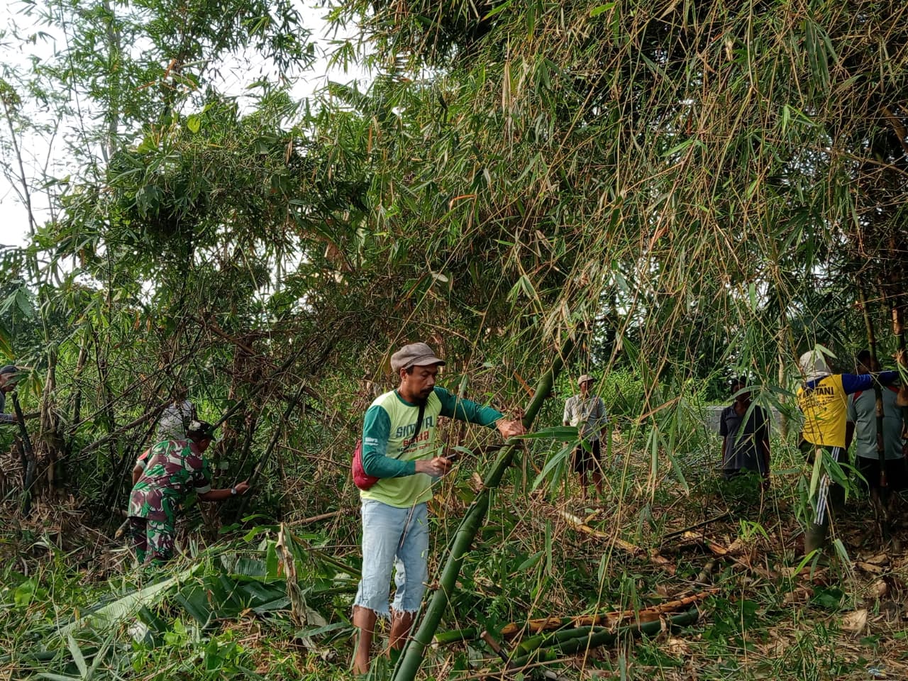 Babinsa Kelurahan Bence Ajak Warga Bersihkan Ranting Bambu Yang Menutupi Akses Jalan Persawahan