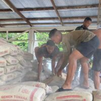 Anggota Satgas TMMD Wiltas ke-127 Kodim 0912/Kubar Turunkan Material Semen untuk Semenisasi Jalan di Linggang Amer