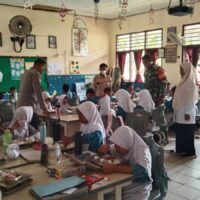 Sinergitas Babinsa Dan Bhabinkamtibmas Waru Kawal MBG Dari Proses Pengemasan Hingga Penyalur Ke Sekolah