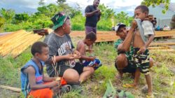 Personel TMMD ke 128 Kodim 1801/Manokwari, Melaksanakan Aktivitas Bakar Singkong dan Bercanda dengan Warga